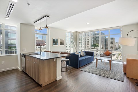 a living room with a kitchen and a large window